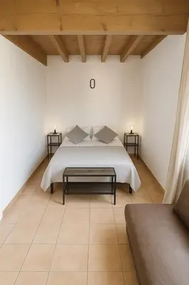 a bedroom with a white bed and two side tables at Appartement près du canal du midi in Mirepeisset
