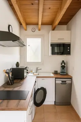 a kitchen with white cabinets and a sink at Appartement près du canal du midi in Mirepeisset