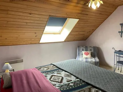 a bedroom with a bed and a ceiling with a window at Ferme-auberge le cochon du Madres in Escouloubre