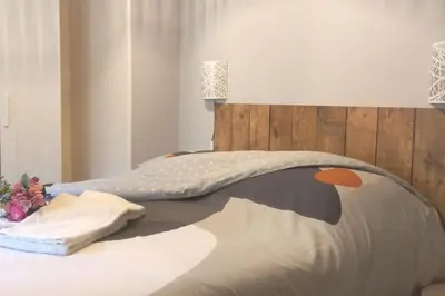 a bedroom with a bed with a head board at Maison au calme avec jardin et parking privé in Rouairoux