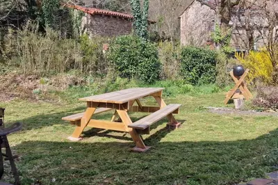 a picnic table in the grass with a ball on it at Maison au calme avec jardin et parking privé in Rouairoux