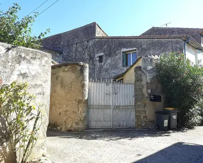 a house with a gate and a white fence at Chambre de charme in Cavanac