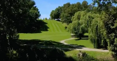 a view of a golf course with trees and a road at Chambre de charme in Cavanac