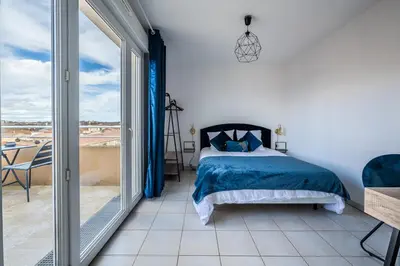 a bedroom with a bed and a balcony at Appartement 