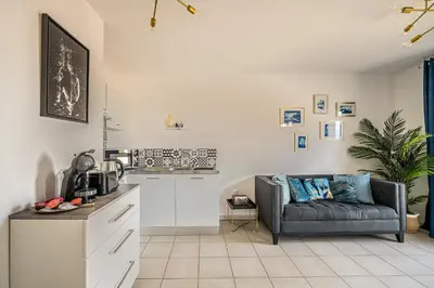 a living room with a couch and a kitchen at Appartement 