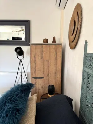 a man sitting on a bed in a bedroom at Studio confortable et calme au millieu des vignes in Moussan