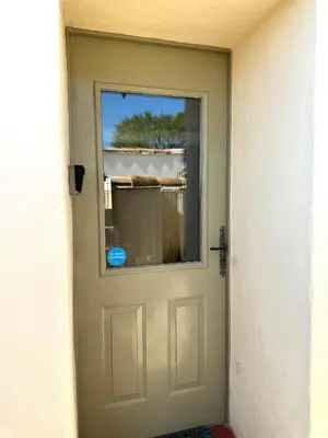 a door with a window on the side of a building at Studio confortable et calme au millieu des vignes in Moussan
