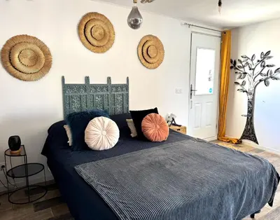 a bedroom with a blue bed with pillows on it at Studio confortable et calme au millieu des vignes in Moussan