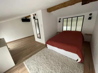 a bedroom with a red bed and a rug at Industrial Lodge 85m² - Loft avec extérieur in Revel
