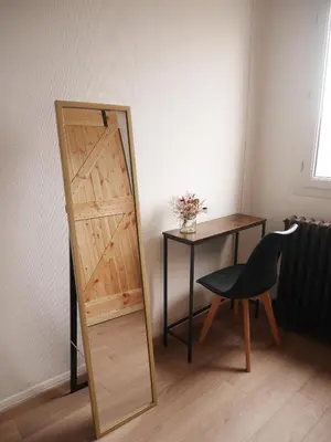 a mirror sitting next to a table and a chair at Le Laurenti in Quérigut