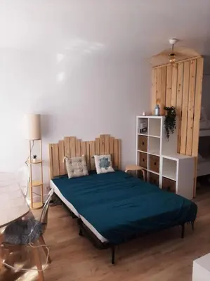 a bedroom with a bed with a wooden headboard at Studio mer Neuf Port la Nouvelle in Port-la-Nouvelle