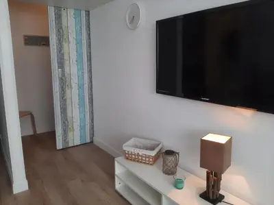 a living room with a flat screen tv on a wall at Studio mer Neuf Port la Nouvelle in Port-la-Nouvelle
