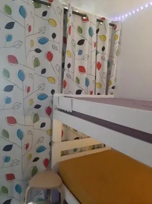 a childs room with a crib and curtains with trees at Studio mer Neuf Port la Nouvelle in Port-la-Nouvelle