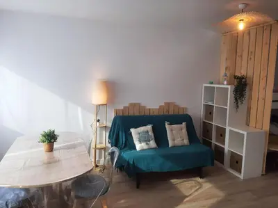 a living room with a blue couch and a table at Studio mer Neuf Port la Nouvelle in Port-la-Nouvelle
