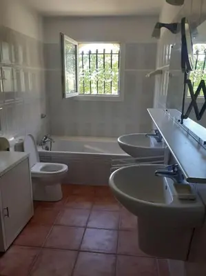 a bathroom with three sinks and a tub and a toilet at Belle villa entre garrigue et rivière in Saint-Chinian