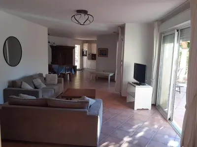 a living room with a couch and a tv at Belle villa entre garrigue et rivière in Saint-Chinian