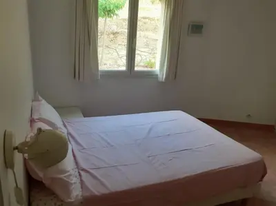 a bed in a room with a window at Belle villa entre garrigue et rivière in Saint-Chinian