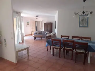 a living room with a table and chairs and a couch at Belle villa entre garrigue et rivière in Saint-Chinian