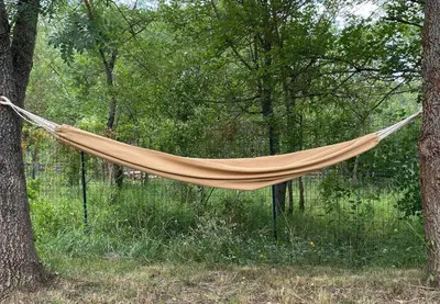 a hammock hanging between two trees in a forest at Zen Experience including Yoga & Healthy food in Ladern-sur-Lauquet