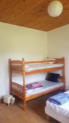 a bedroom with two bunk beds and a wooden ceiling at Gite de l'école in Saint-Louis-et-Parahou