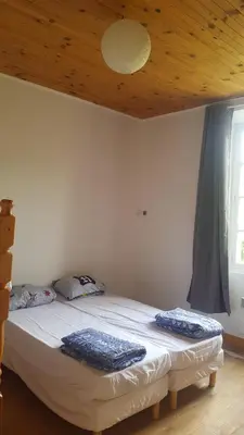 a bedroom with a bed with a wooden ceiling at Gite de l'école in Saint-Louis-et-Parahou