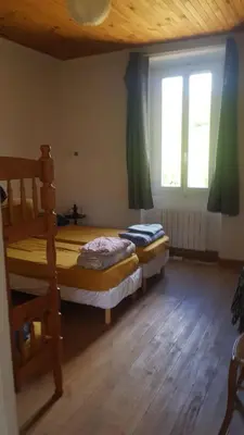 a bedroom with two bunk beds and a window at Gite de l'école in Saint-Louis-et-Parahou