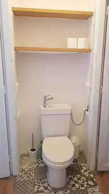 a bathroom with a white toilet in a room at Gite de l'école in Saint-Louis-et-Parahou