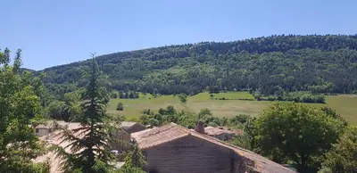 a village with a mountain in the background at Gite de l'école in Saint-Louis-et-Parahou