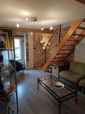 a living room with a couch and a table at Charmante maison village QUERIGUT in Quérigut