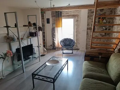 a living room with a couch and a glass table at Charmante maison village QUERIGUT in Quérigut