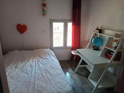 a bedroom with a bed and a desk and a shelf at Charmante maison village QUERIGUT in Quérigut