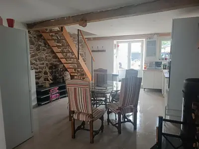a living room with a staircase and a table and chairs at Charmante maison village QUERIGUT in Quérigut