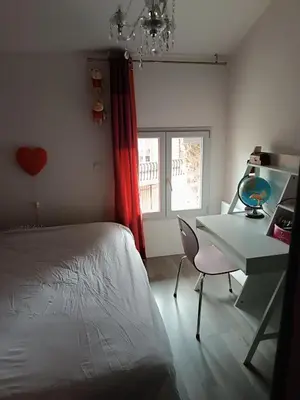 a bedroom with a bed and a desk and a table and chair at Charmante maison village QUERIGUT in Quérigut