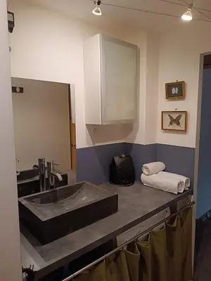 a bathroom with a sink and a mirror at Charmante maison village QUERIGUT in Quérigut