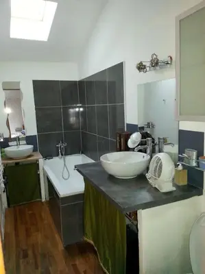 a bathroom with two sinks and a bath tub and a sink at Charmante maison village QUERIGUT in Quérigut