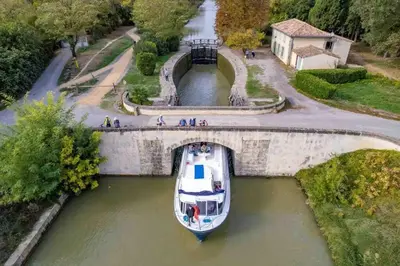 a boat in the water under a bridge at Domaine VILLECARLA Gîte 1, Canal du Midi Carcassonne in Villedubert