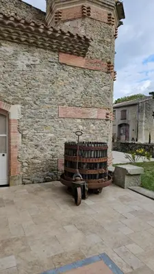 a stack of wine barrels sitting next to a brick building at Domaine VILLECARLA Gîte 1, Canal du Midi Carcassonne in Villedubert