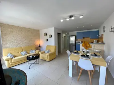 a living room with a yellow couch and a table at Gite Thym spa au coeur d'une oliveraie des Corbières in Saint-Jean-de-Barrou