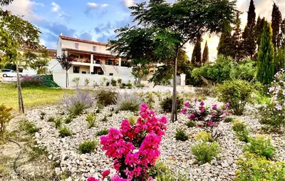 a garden with pink flowers in front of a house at Cozy Home In Stjean-De-Minervois in Saint-Jean-de-Minervois