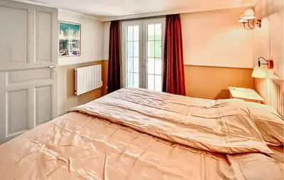 a bedroom with a large bed in front of a window at Cozy Home In Stjean-De-Minervois in Saint-Jean-de-Minervois