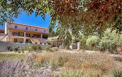 a building with a garden in front of it at Cozy Home In Stjean-De-Minervois in Saint-Jean-de-Minervois