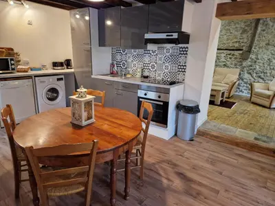 a kitchen and dining room with a wooden table and chairs at Le Grand Cerf - 4 Couchages in Nalzen