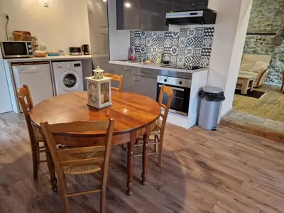 a kitchen and dining room with a wooden table and chairs at Le Grand Cerf - 4 Couchages in Nalzen