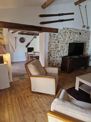 a living room with couches and a stone fireplace at Le Grand Cerf - 4 Couchages in Nalzen