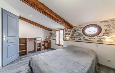 a bedroom with a bed and a round window at Awesome Home In Peyriac-Minervois in Peyriac-Minervois