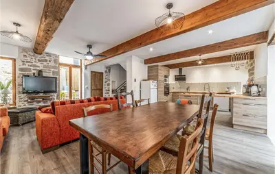 a kitchen and living room with a wooden table and chairs at Awesome Home In Peyriac-Minervois in Peyriac-Minervois