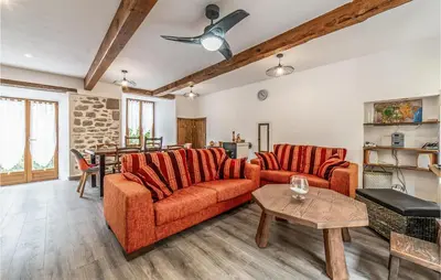 a living room with two orange couches and a table at Awesome Home In Peyriac-Minervois in Peyriac-Minervois