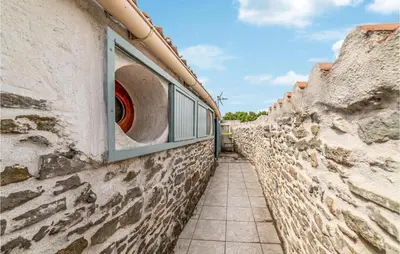 a narrow alley between two stone walls with a window at Awesome Home In Peyriac-Minervois in Peyriac-Minervois