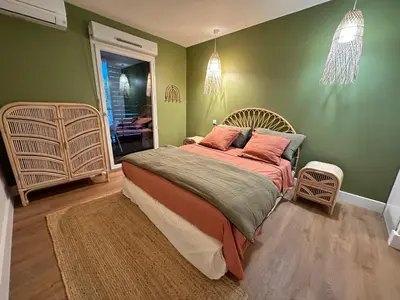 a bedroom with a large bed with green walls at Le Quai Secret d'Augustine centre &vue canal avec draps serviettes et ménage in Narbonne