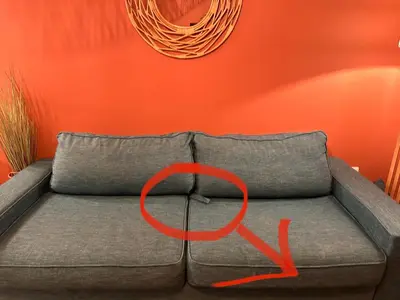 a couch with a red symbol on it in a room at Le Quai Secret d'Augustine centre &vue canal avec draps serviettes et ménage in Narbonne